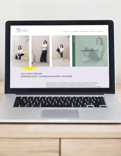 Laptop auf Holztisch zeigt Website ‚Strukturen & Impulse‘ mit Fotos einer Frau in Business-Kleidung, lila Logo und Text